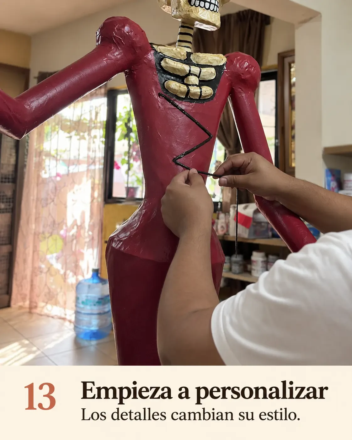 Manos entrelazando cinta negra en el corpiño bordó